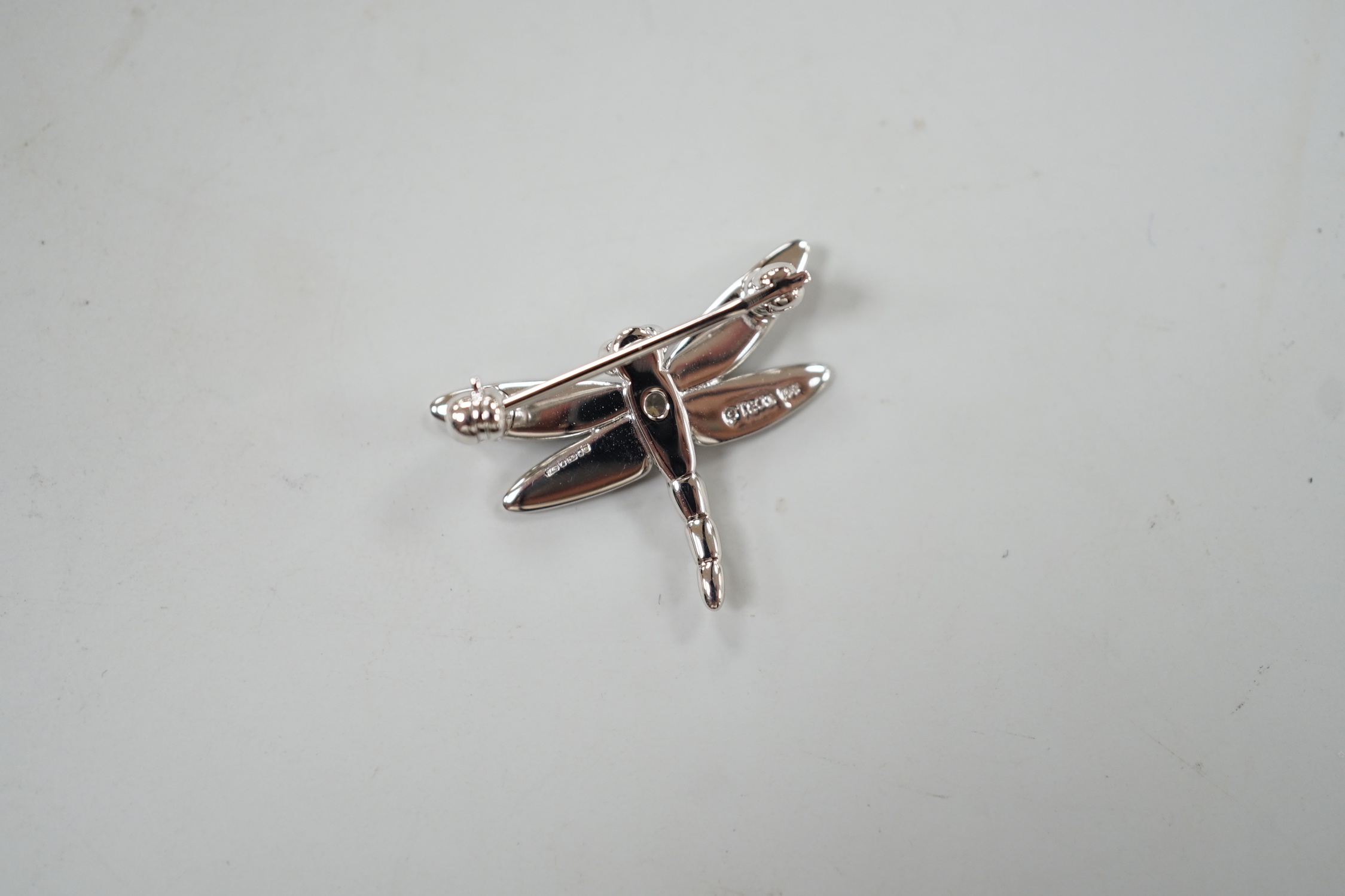 A modern Tiffany & Co 18ct white gold and single stone diamond set dragonfly brooch, width 23mm, 2.5 grams.